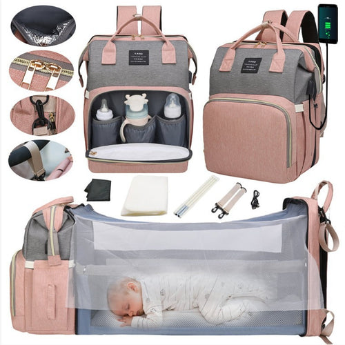 Multifunctional baby bag with various compartments and accessories, including a baby sleeping in a mesh section.